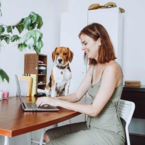 A woman at home with her dog checking reviews online